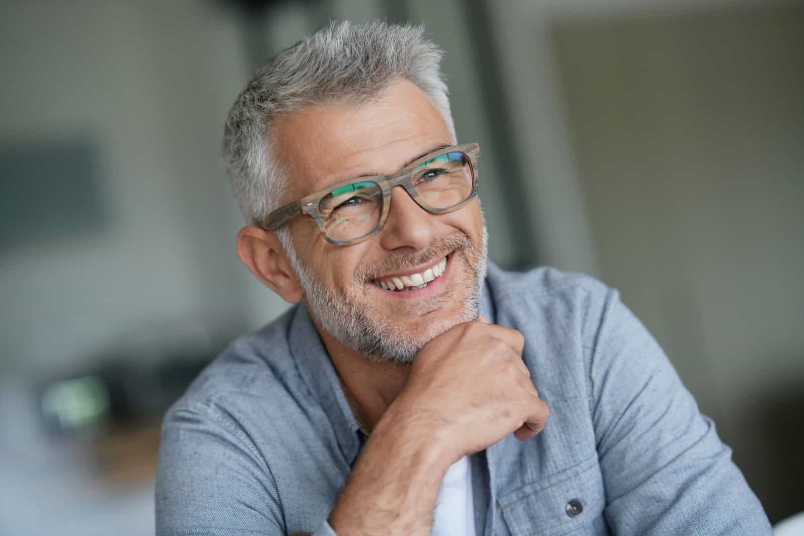 A middle aged man wearing glasses, smiling
