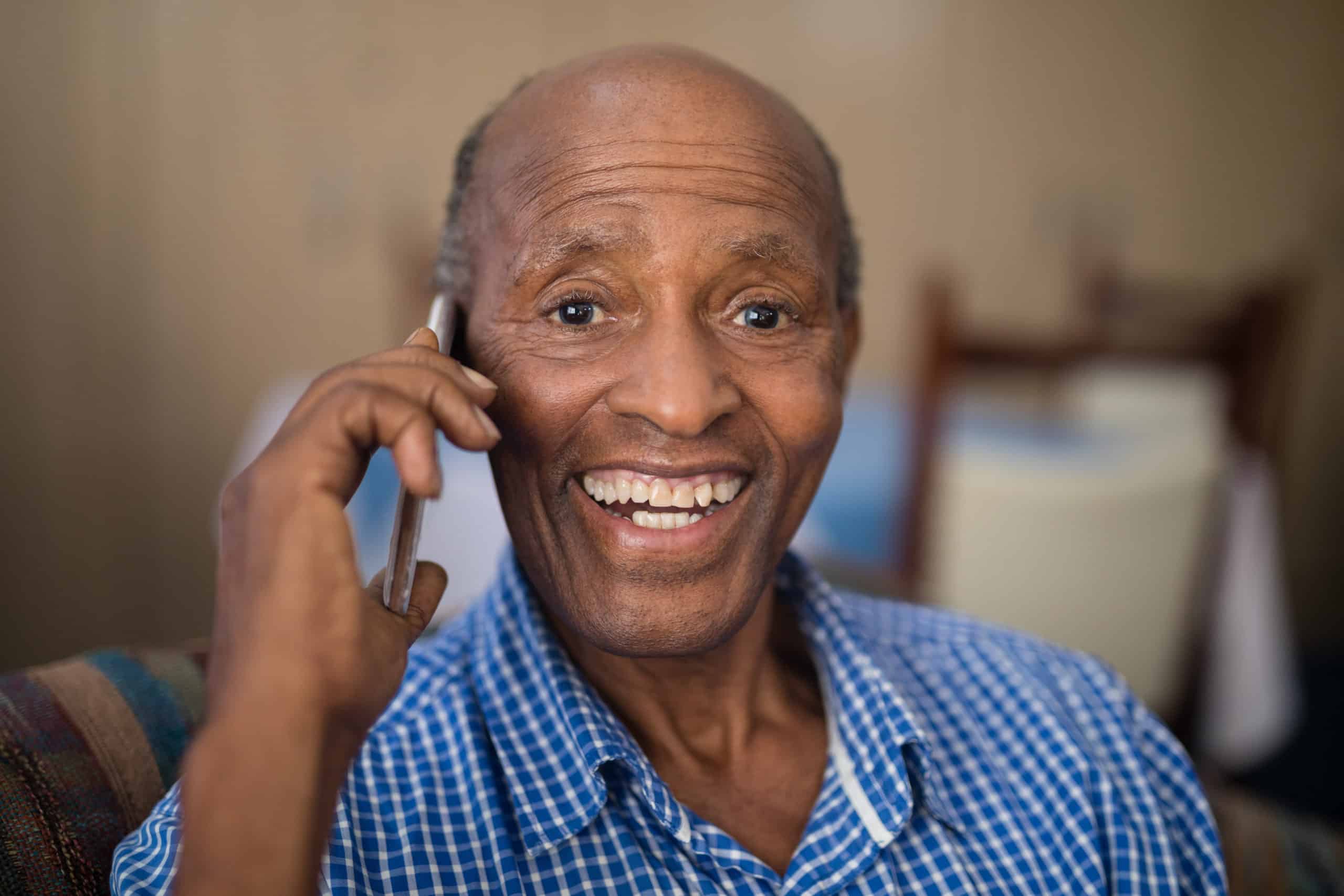 a man smiling and talking on the phone