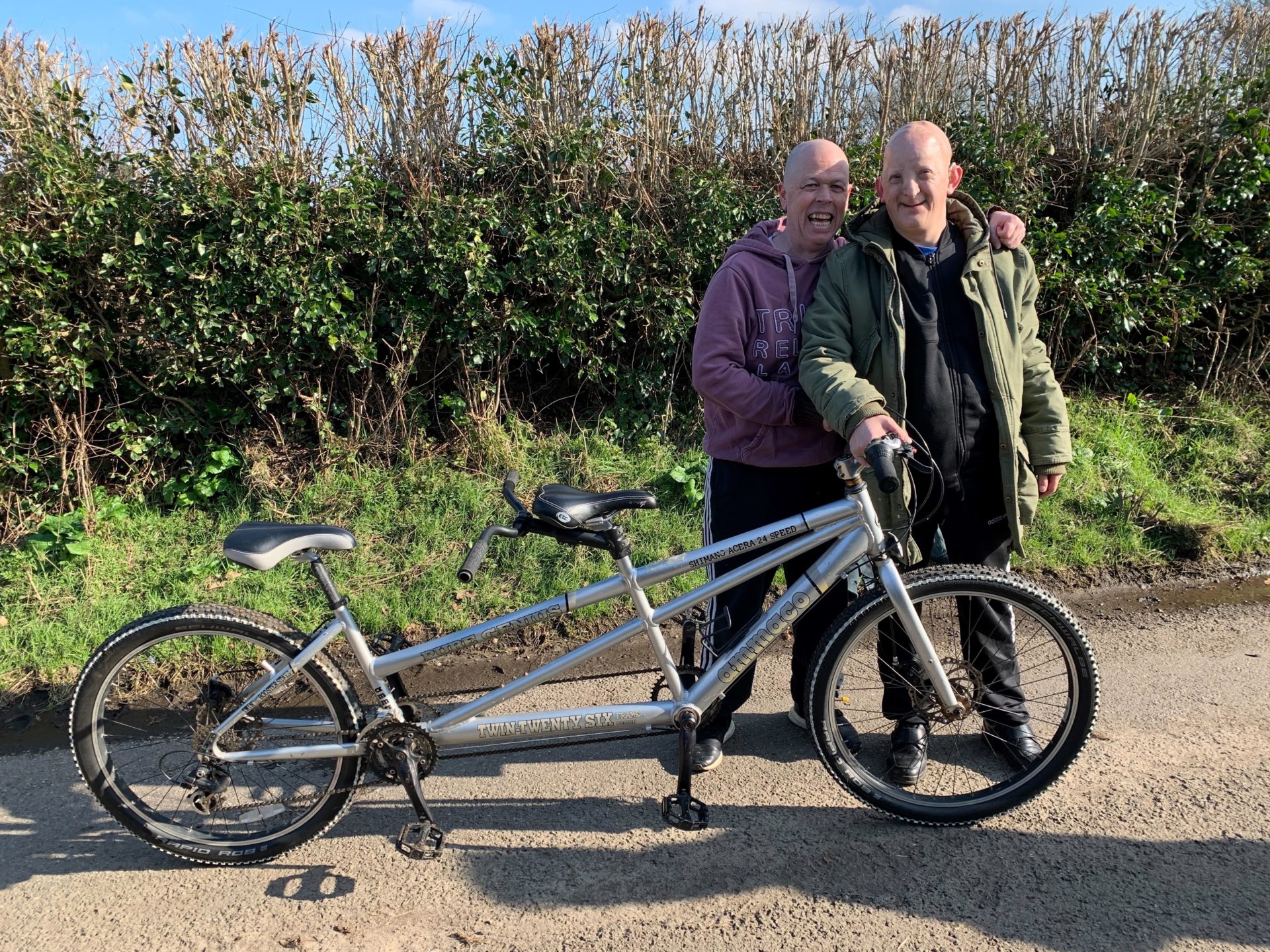 Paul and Lee standing next to each other in front of their tandem bike.