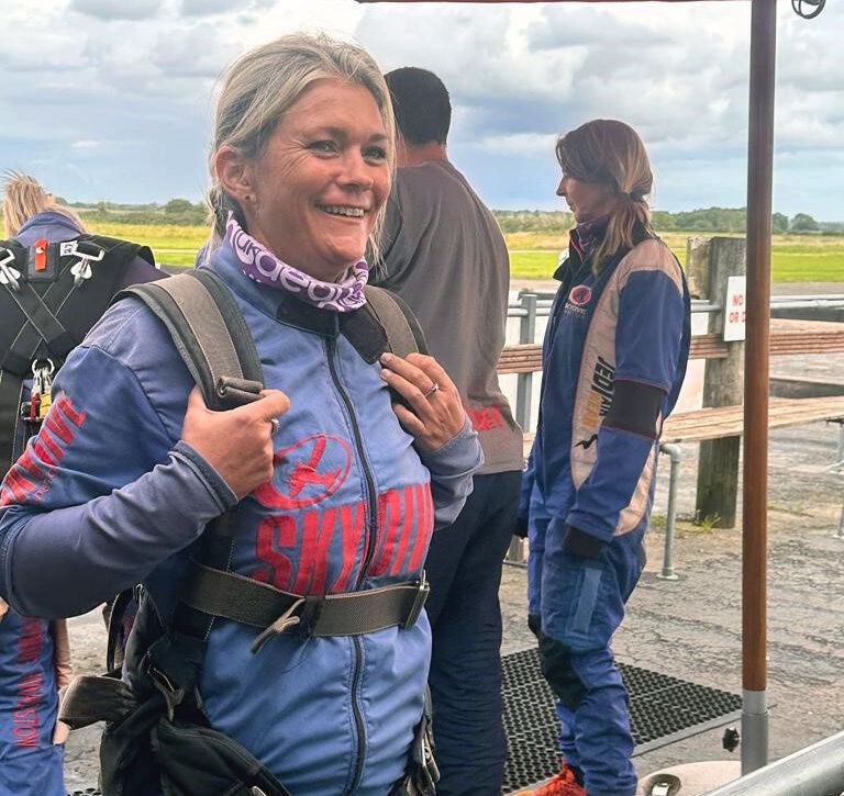Events - Members - Staff - Angela Priestley RE23-54 - outside in sky dive suit - 2023