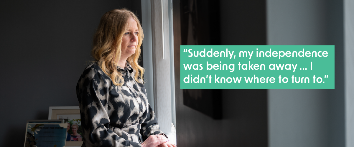 Victoria is standing in a darkened room looking out of window at the light outside, conveying a sense of isolation. She has long, wavey blonde hair and is wearing a black and white patterned blouse. A caption reads, "Suddenly, my independence was being taken away... I didn't know where to turn to."