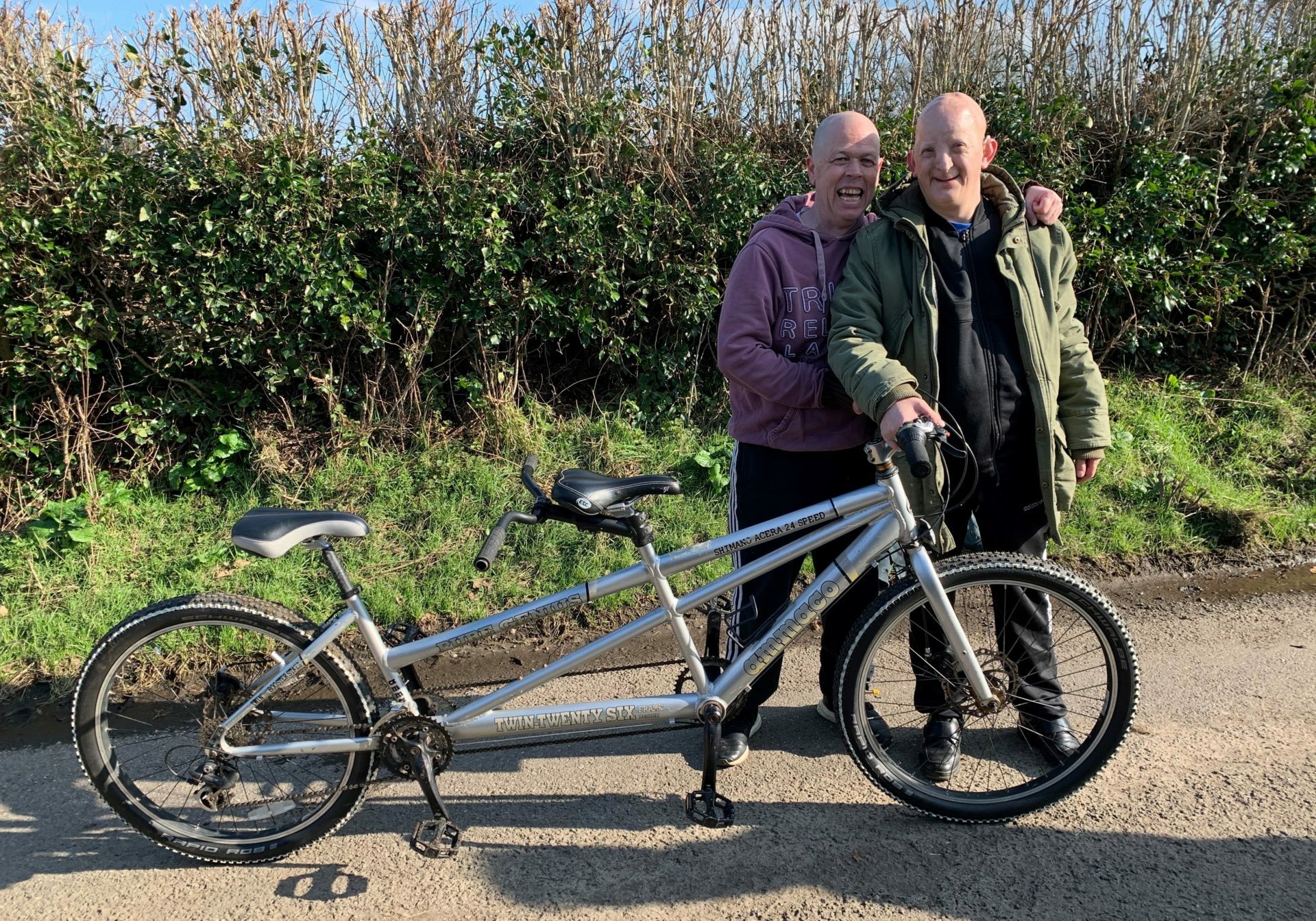 Paul and Lee standing next to each other in front of their tandem bike.