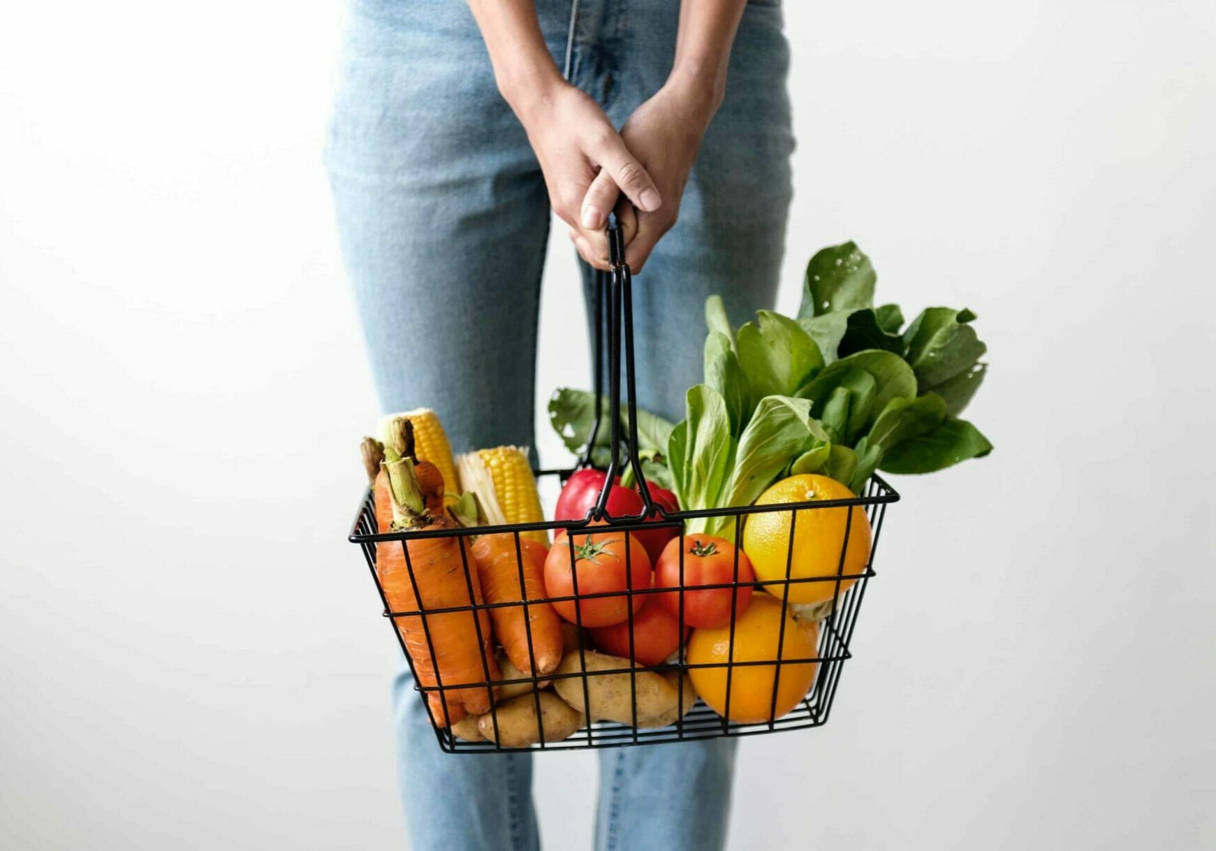 Person holding a basket full of vegetables