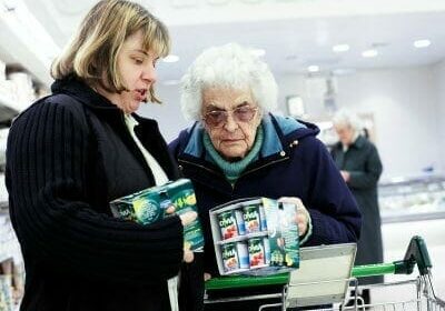 an elderly lady being helped select her shopping
