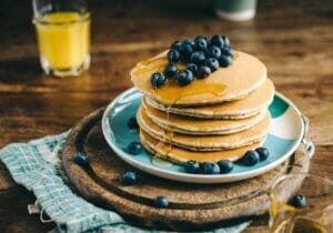 A stack of pancakes and a glass of orange juice